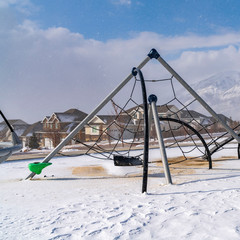 Square Climbing frames on a playground blanketed with snow on a sunny winter day