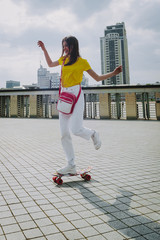 Happy hipster girl enjoying skating on penny board