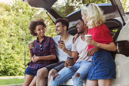 Happy travelers sitting in car back