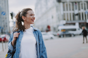 Pretty smiling young female walking around city
