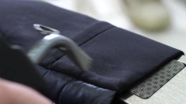 Close-up of suit jacket sleeve cleaned with stain remover and dried during professional dry clean. Chemical detergent applied to fabric using sprayer and then dried by steam dryer