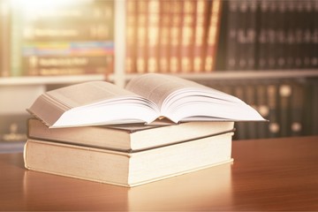 Stacked books on desk at library
