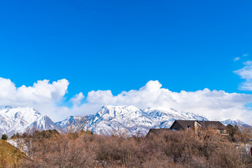 Magnificent mountain coated with snow against a vivid sky with puffy clouds