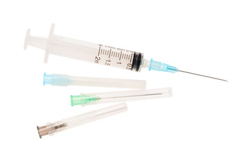 Fototapeta premium Syringe and three needles in plastic shells. 2 ml disposable syringe close up, isolated on white background without shadow