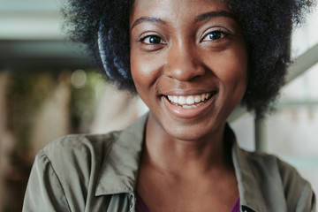 Portrait of happy African woman wearing headphones and listening to music