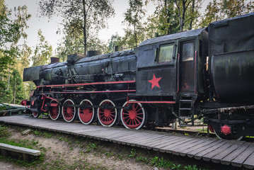 Fototapeta na wymiar Old steam locomotive with Soviet star in regional promotion park in Szymbark, Poland