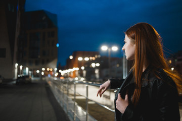 Stylish young woman standing in the night city. Dating, waiting, relaxing concept.