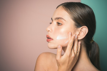Keep skin hydrated regularly moisturizing cream. Taking good care of her skin. Beautiful woman spreading cream on her face. Skin cream concept. Facial care for female. Fresh healthy skin concept