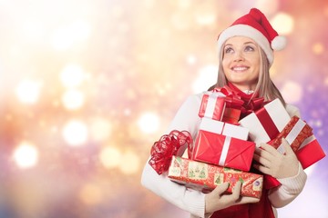 Smiling woman with many gift boxes on background