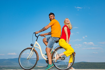 Beautiful summer day. Summer couple. Sexy couple in love. Couple in love riding a bike. Active people. Stylish and loving couple enjoying.