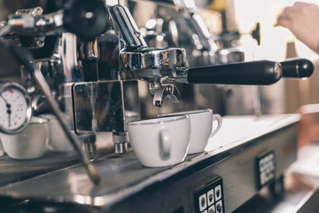 Fototapeta na wymiar Coffee machine dispensing freshly brewed coffee into two cups