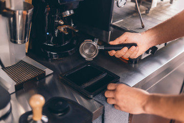 Experienced barista cleaning filter holder after using it