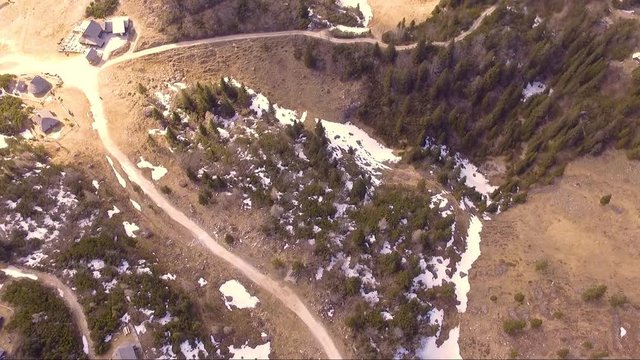 Flying over the beautiful Velika planina full of spruce, little houses and mountains in the back from bird's eye view. Aerial camera shot. Landscape panorama sunny day. Slovenia