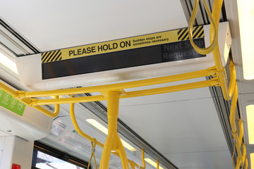 ST KILDA, AUSTRALIA - December 26, 2017: A yellow and black Please Hold On caution sign in a tram