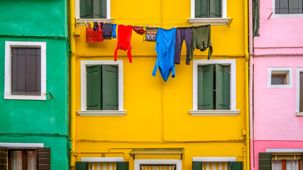 Laundry hanging to dry from clothesline in colorful neighborhood on Burano Island, Venice, Italy