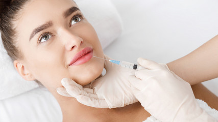 Cosmetologist Making Botox Injection In Female Lips