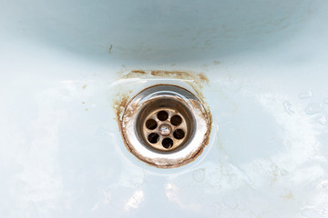 Dirty sink drain mesh, hole with limescale or lime scale and rust on it, dirty rusty bathroom washbowl