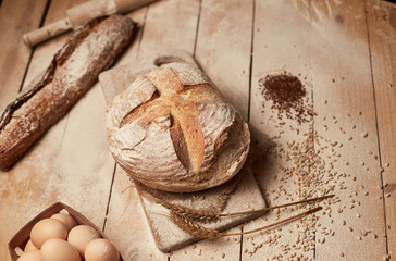 Bakery gold rustic crusty loaves of bread and  on wooden background. Still life captured from above (top view, flat lay).