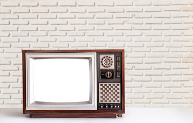 Old television with a white brick wall