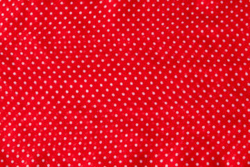 Red fabric with the white polka dots as a background texture composition