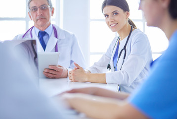 Serious medical team discussing patient's case in a bright office