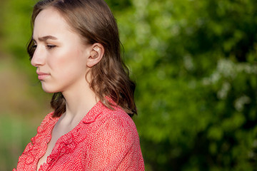 Close-up Of Female Hands Putting Hearing Aid In Ear. Modern digital in the ear hearing aid for...