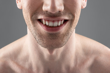 Obraz premium Young man smiling and demonstrating his white healthy teeth