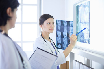 Two female doctors pointing at x-rays in a hospital