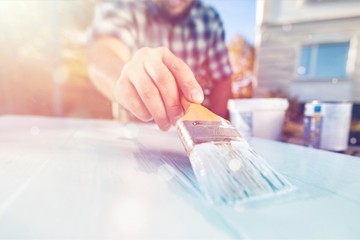 Man with paintbrush painting on the wooden