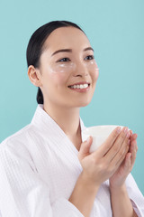 Half length of charming Asian lady with patches under eyes in studio