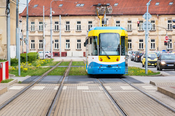 Obraz premium Colourful tram runs on tramway track over green grass area in Kosice (SLOVAKIA)