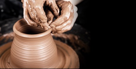 Hands of potter making clay pot