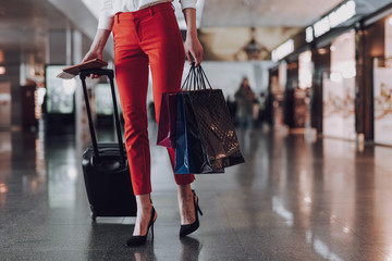Stylish girl is walking to plane with baggage