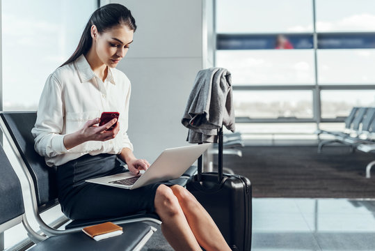 Business lady with laptop and smartphone in airport