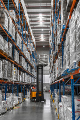 galpão logistica e distribuição caixas trabalhadores e empilhadeira em operação