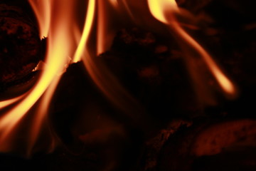 Glowing Yellow and orange colour fire is flamming and burning on a black background.Abstract design