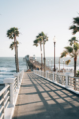 Ramp to the pier and palm trees overlooking the Pacific Ocean, in Oceanside, San Diego County,...