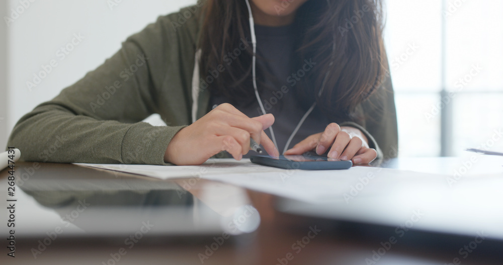 Wall mural Woman do revision with cellphone at home