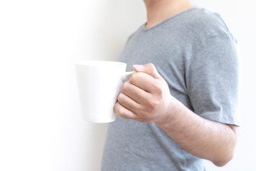 立ってマグカップを持つ男性