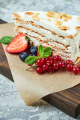 Strawberry meringue cake with almond petals, on newspaper 