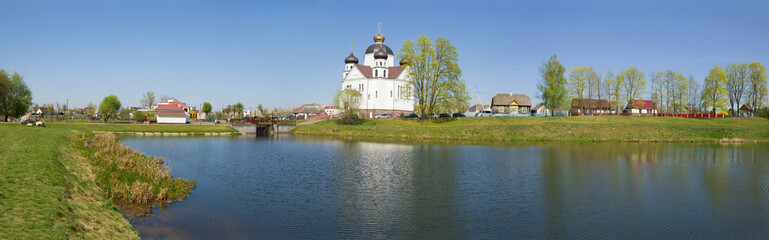 Fototapeta na wymiar Panorama overlooking the Transfiguration Church on a sunny April day. Smorgon, Belarus