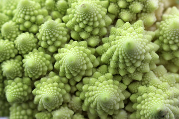 Abstract organic green spiral texture formed from close up detail of Romanesco broccoli, also known...