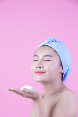 Beautiful woman asia is washing her face on pink background. Cosmetology and Spa.