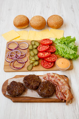 Burger ingredients on a white wooden table, side view. Closeup.