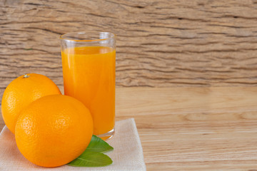Obraz na płótnie Canvas Glass of orange juice placed on wood.