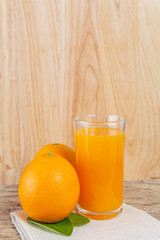 Glass of orange juice placed on wood.