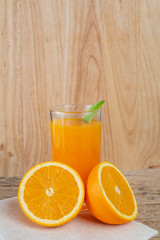 Glass of orange juice placed on wood.