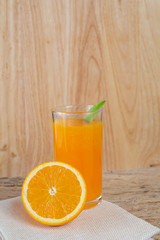 Glass of orange juice placed on wood.