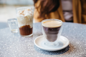 Frothy Nitro Cold Brew Coffee in drinking glass on granite top table with blur background.