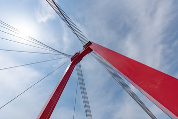 Willemsbrug bridge red cable bridge against blue sky and white clouds, Rotterdam, Netherlands